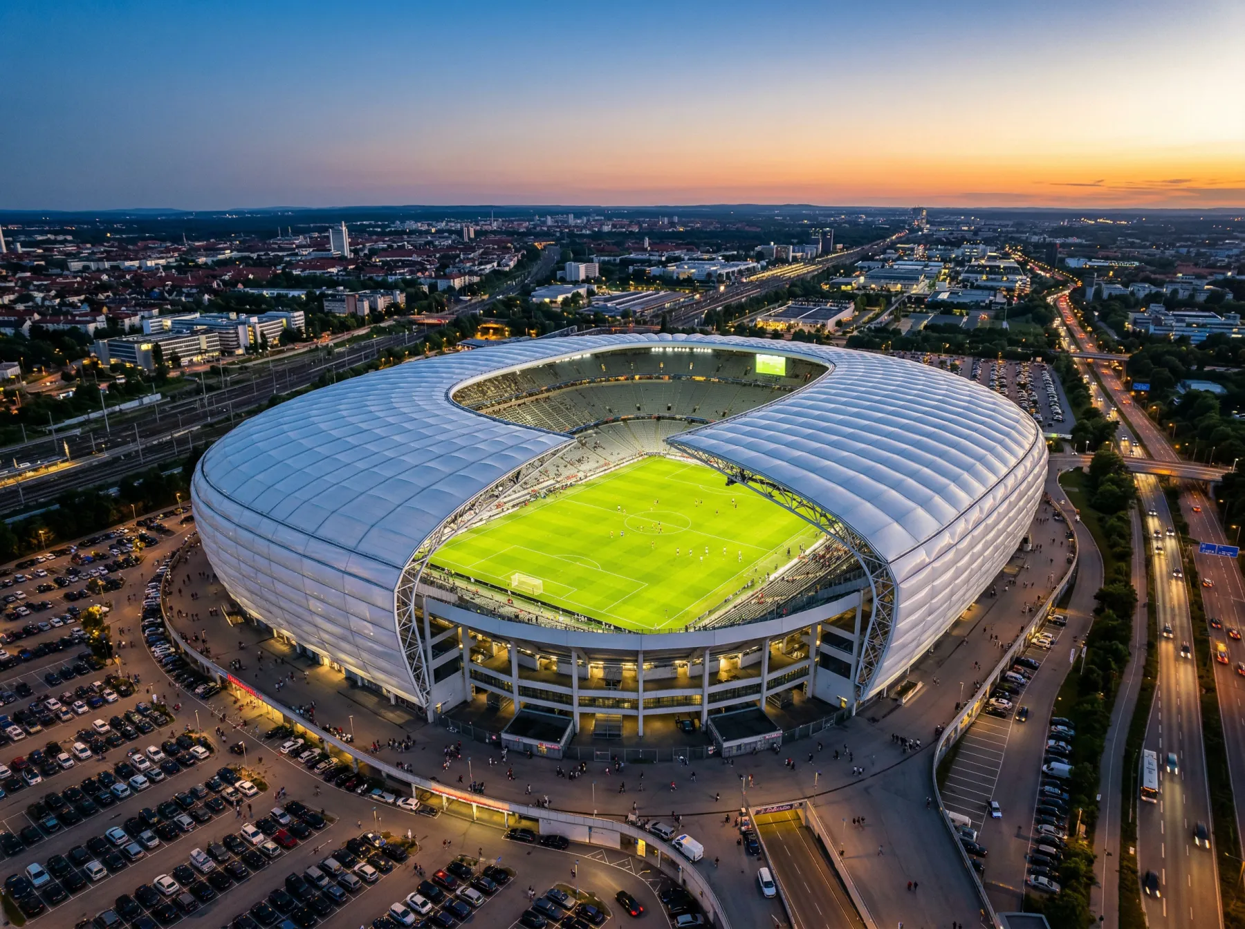 Aerial view of a modern domed football stadium with a retractable roof open on a clear summer evening
